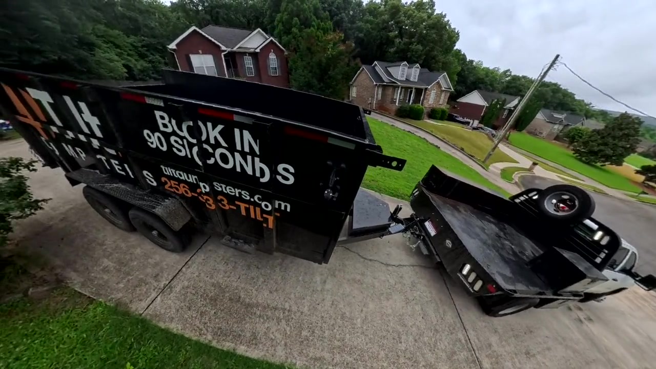 The Tilt Dumpsters trailer backed into a customer's driveway by the delivery truck